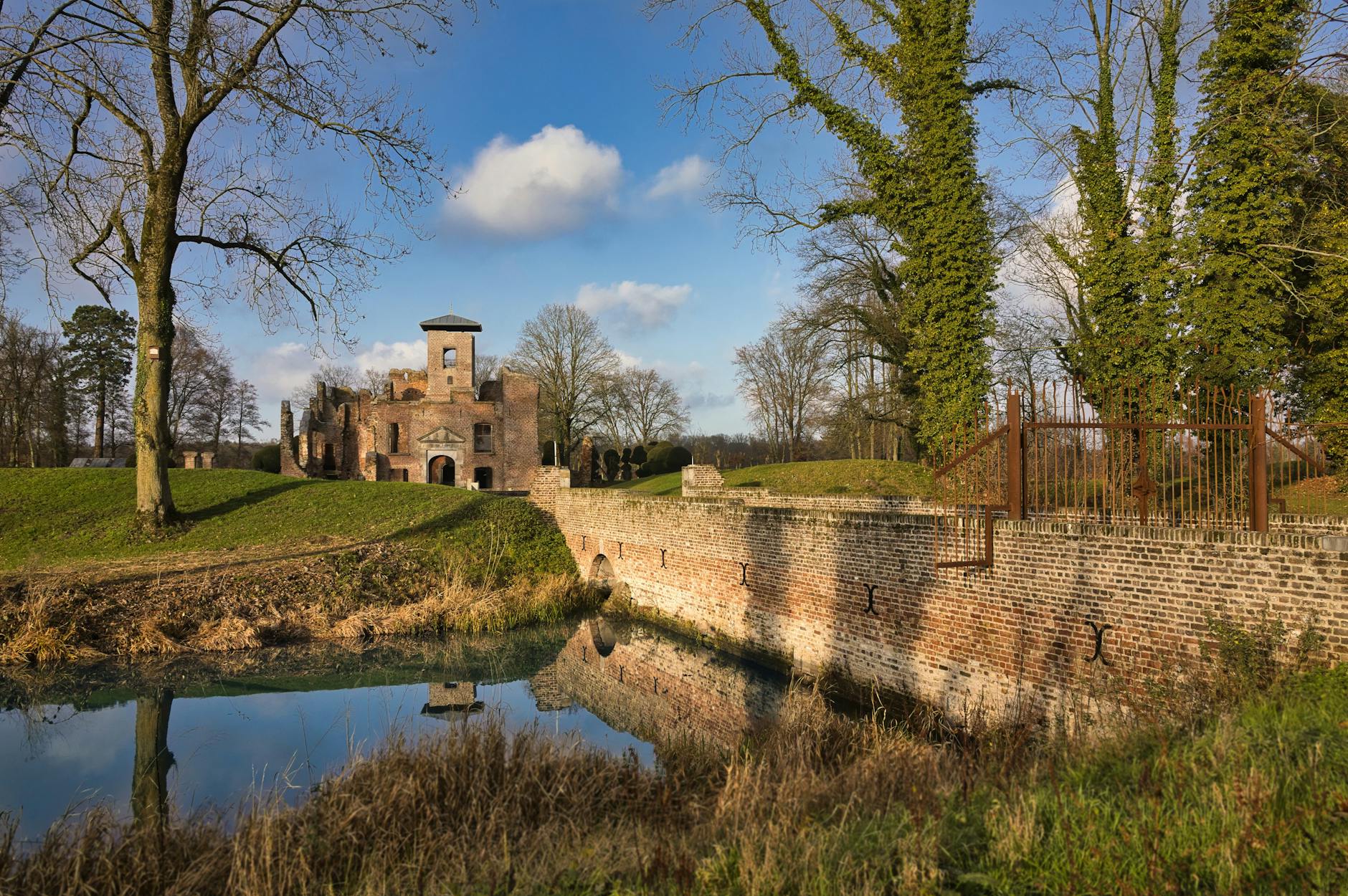 Ceglany zamek nad fosą wśród jesiennych drzew na Mazowszu