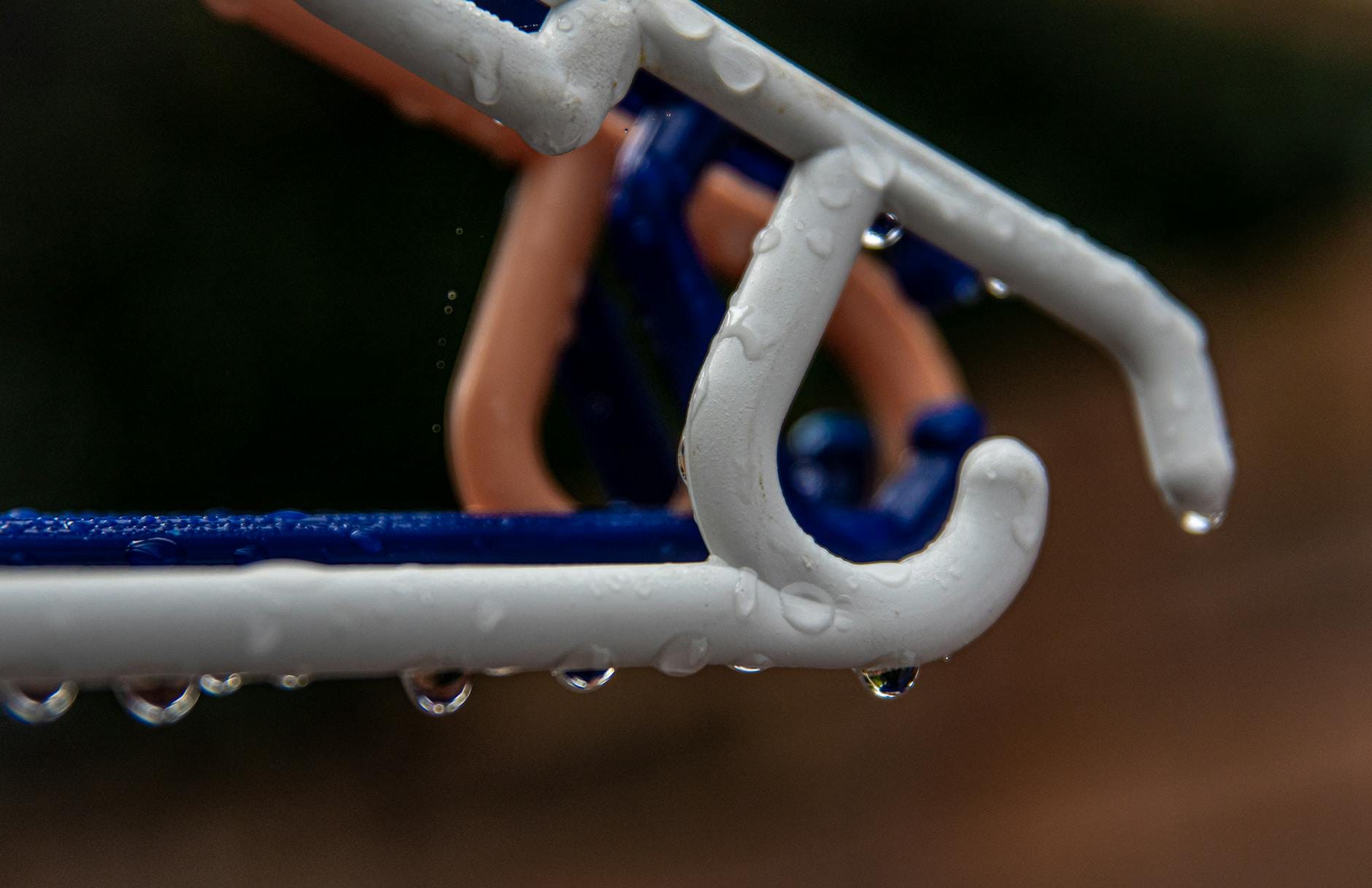 Krople deszczu na plastikowym wieszaku na ubrania o poranku