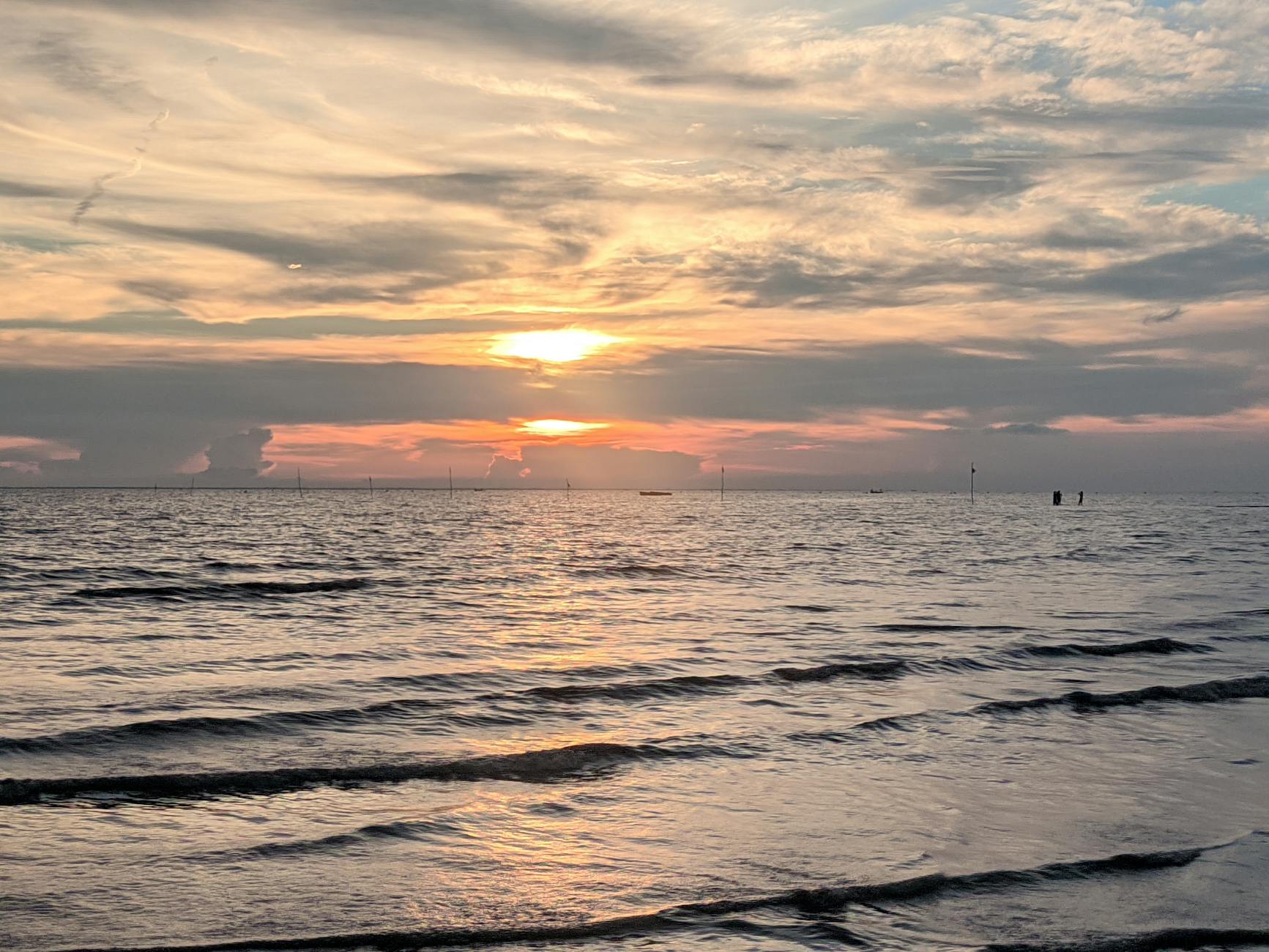 Spokojny zachód słońca nad morzem z delikatnymi falami