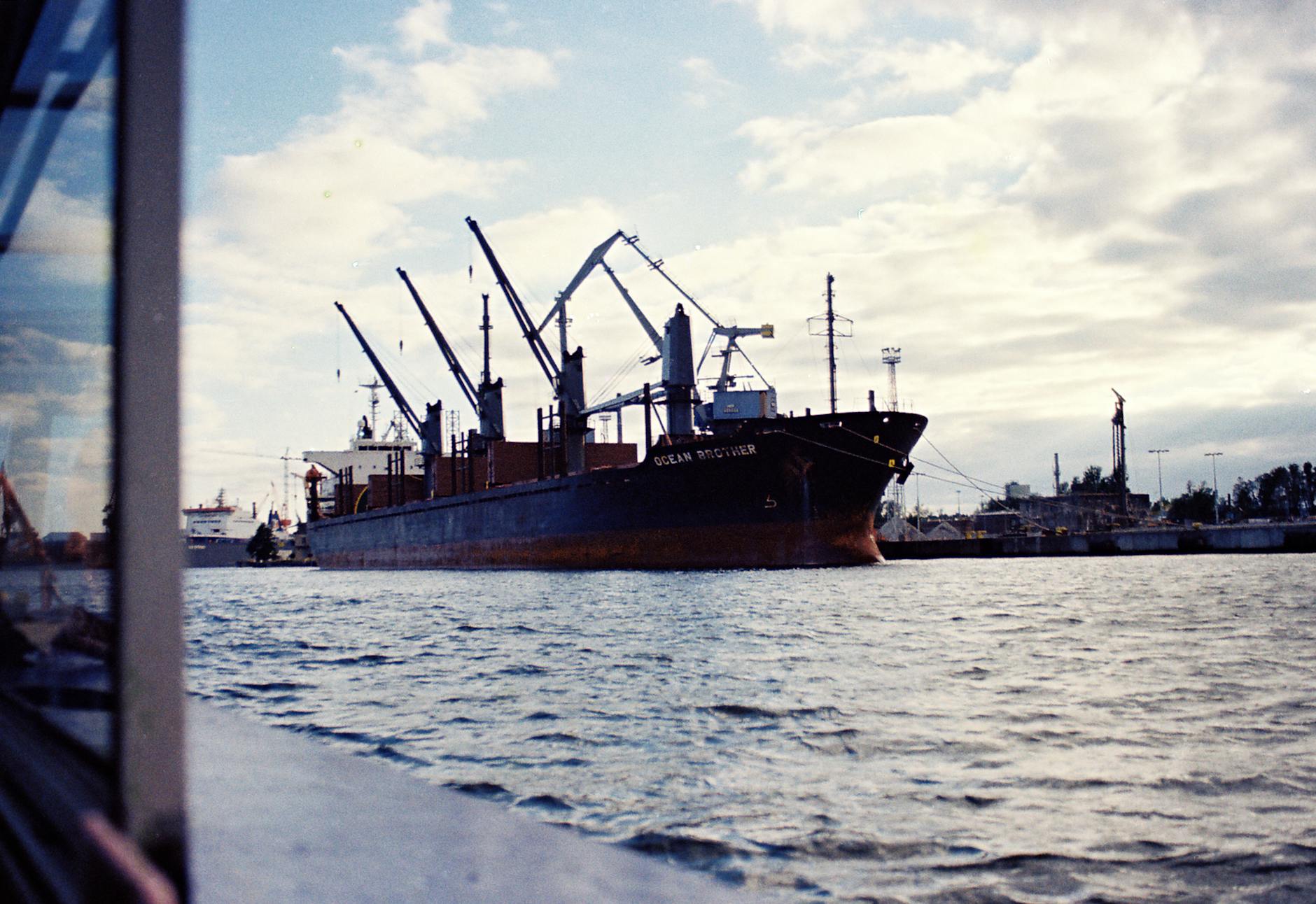 Statek towarowy w porcie Gdańsk na tle zabudowy przemysłowej o zmierzchu