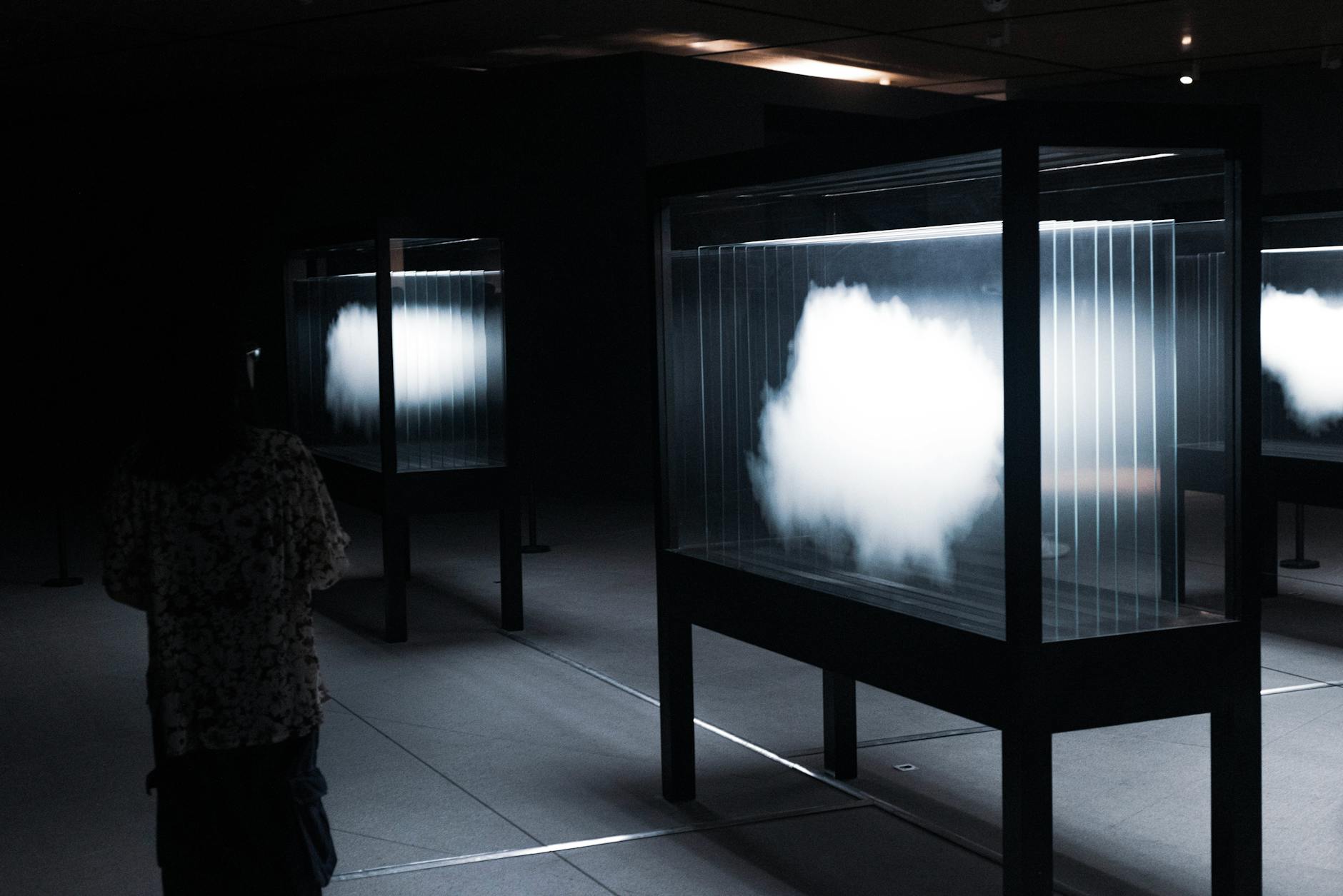 Sylwetka osoby oglądającej abstrakcyjną instalację świetlną w muzeum