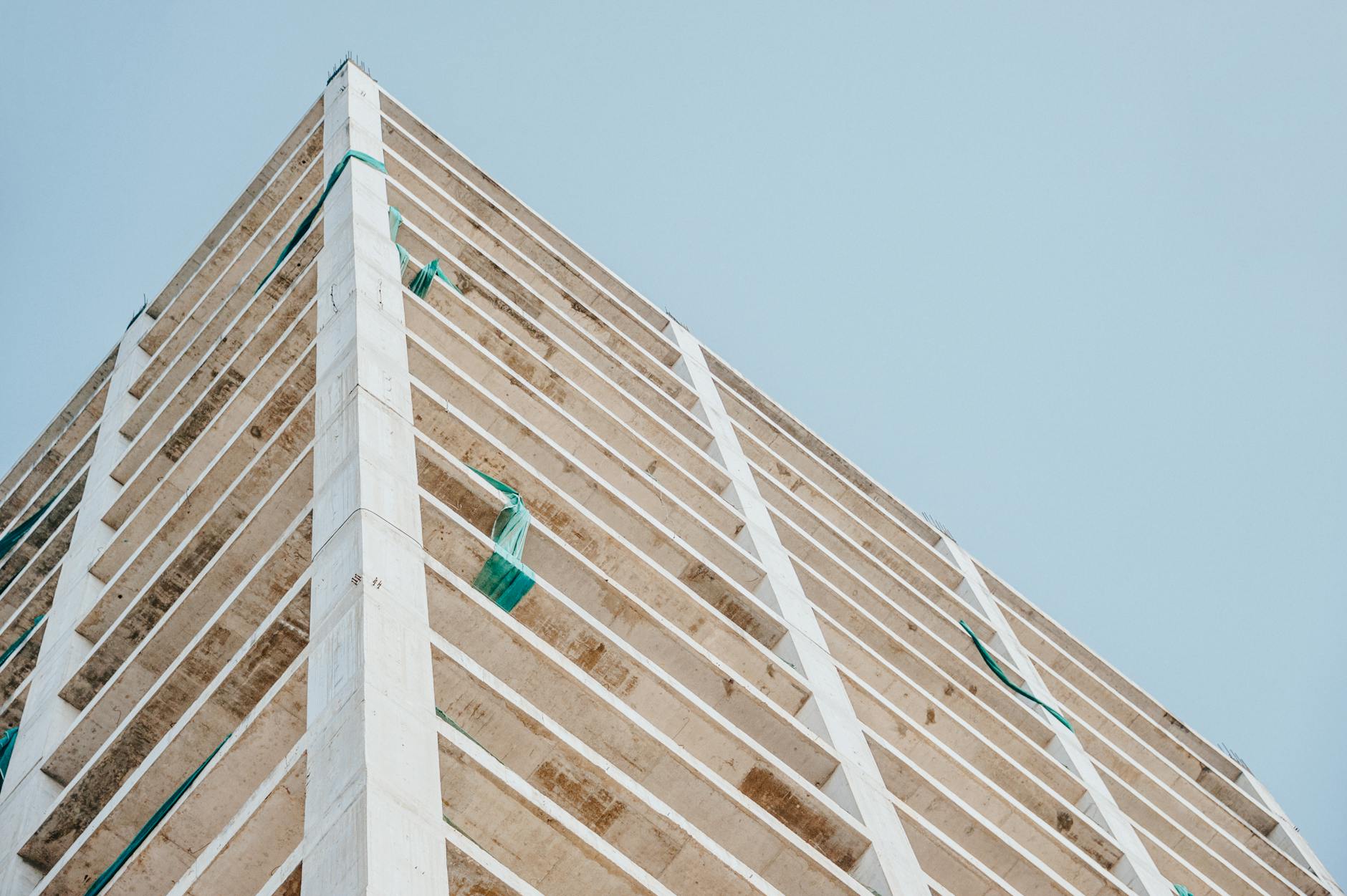 Żelbetowy wieżowiec w budowie na tle czystego nieba