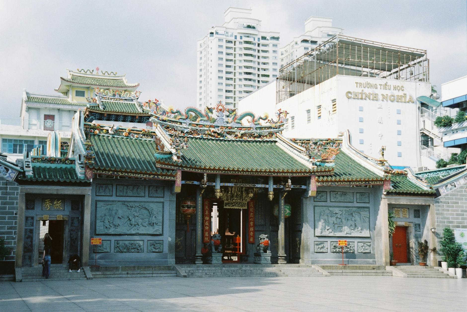 Zdobiona chińska świątynia w Ho Chi Minh w otoczeniu miejskiej zabudowy