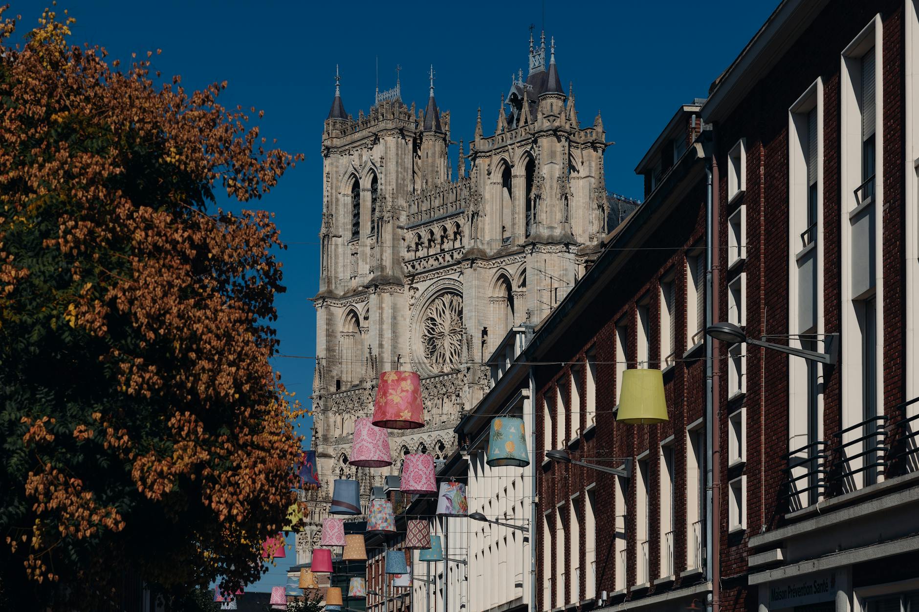 Gotycka katedra wśród kolorowych lamp i jesiennych drzew