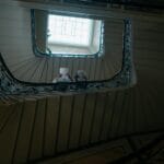 Ornamentalna klatka schodowa w kamienicy z widocznym świetlikiem nad nią