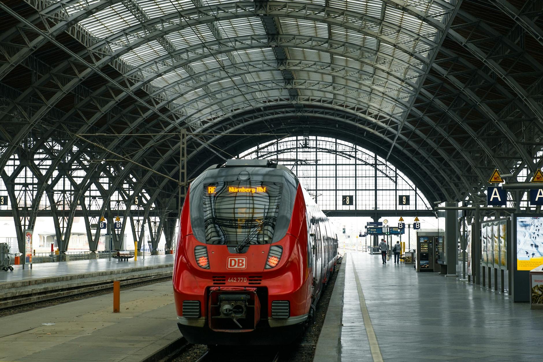 Czerwony pociąg na tle szklanego sklepienia dużego dworca