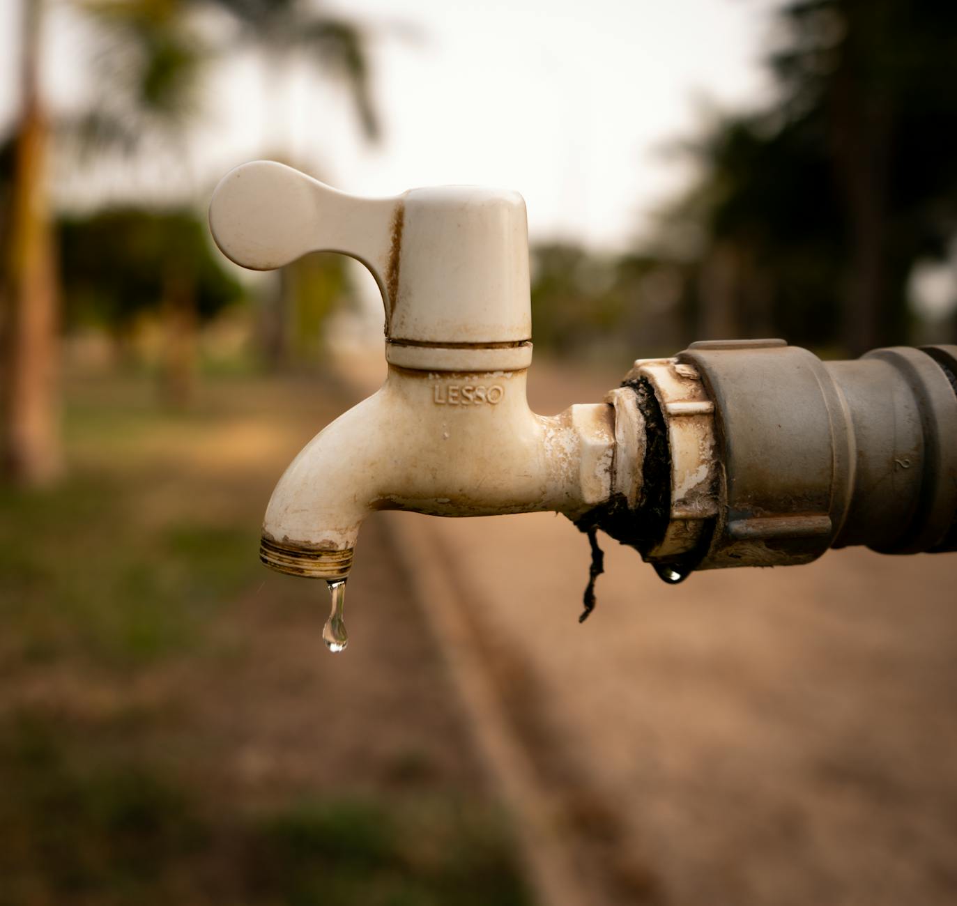 Kropla wody skapująca z zewnętrznego kranu, symbol oszczędzania wody